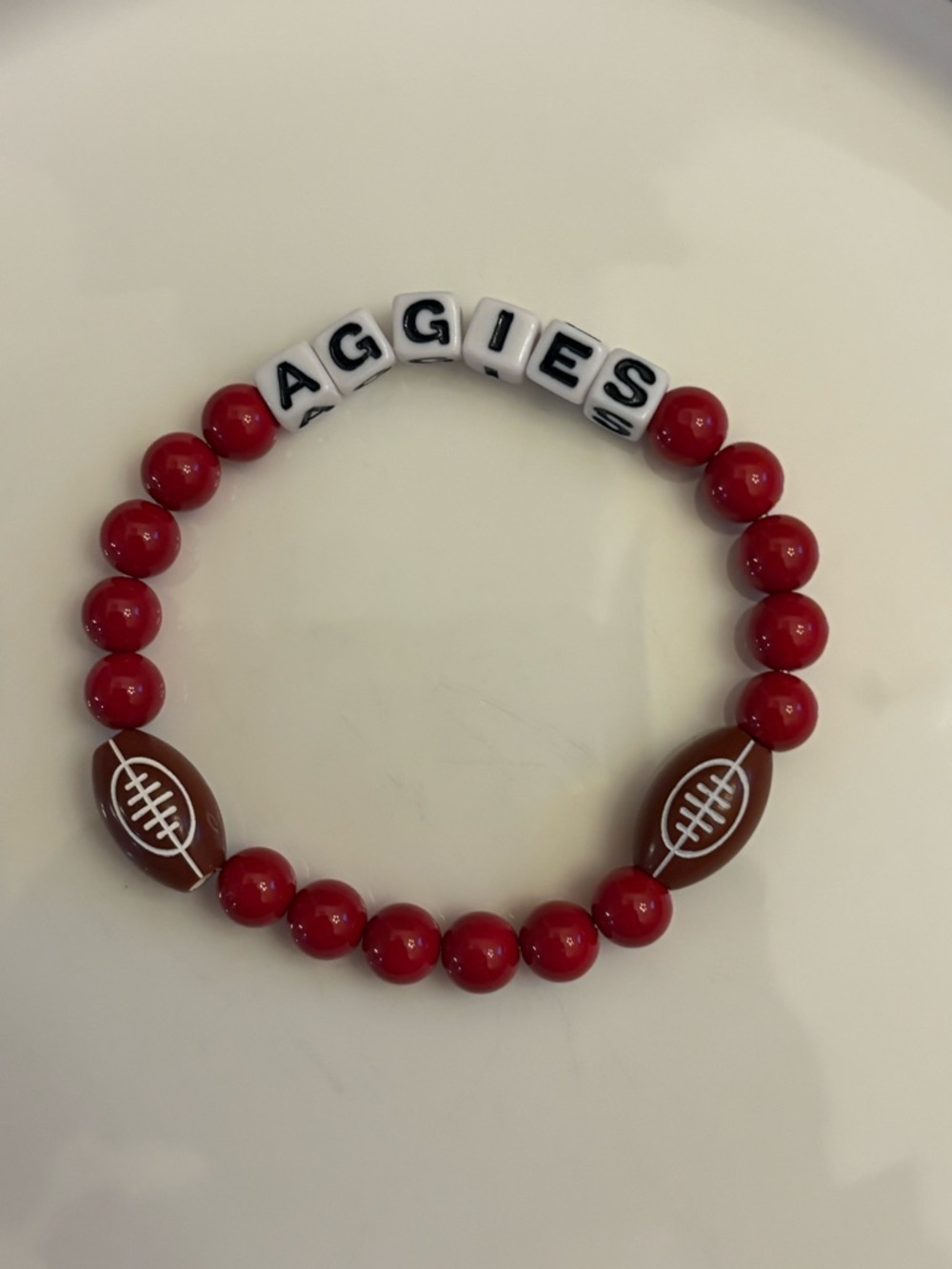 Burgundy Bracelet with AGGIES Lettering in black and Football Accents